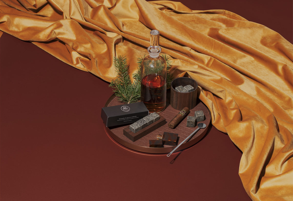 Coffret Lithologie, pierres à whisky et carafe sur un drapé doré